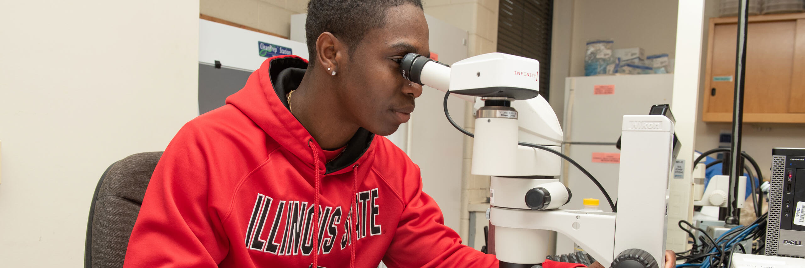 Student looks into a microscope.